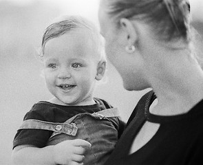 Image showing Loving mother with baby girl in arms. Black and white