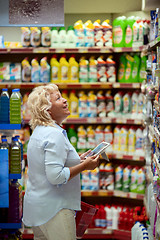 Image showing A smiling middle aged woman in a household section of a supermarket