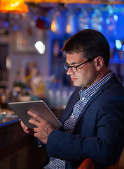 Image showing He cannot get away from his job even in the bar