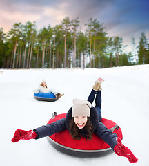 Image showing happy teenage girl sliding down hill on snow tube