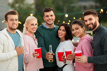 Image showing friends with drinks in party cups at rooftop