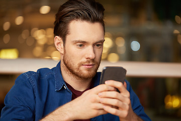 Image showing close up of man with smartphone at restaurant