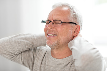 Image showing senior man suffering from neckache at home