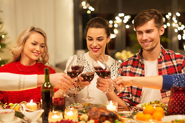 Image showing happy friends drinking red wine at christmas party