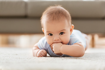 Image showing sweet little asian baby boy lying on floor at home