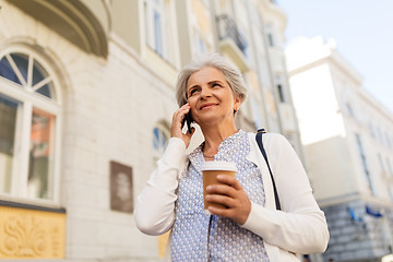 Image showing senior woman calling on smartphone in city