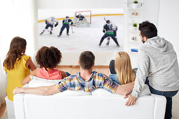 Image showing friends watching ice hockey on projector screen