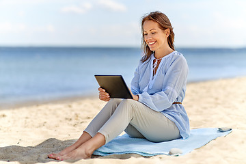 Image showing happy smiling woman with tablet pc on summer beach