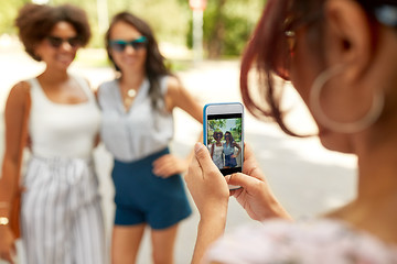 Image showing woman photographing her friends in summer park