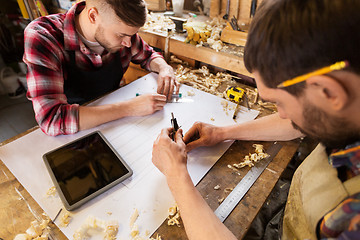 Image showing carpenters with blueprint and dividers at workshop