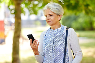 Image showing happy senior woman with smartphone at summer park