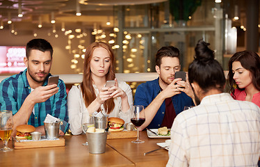 Image showing friends with smartphones at restaurant