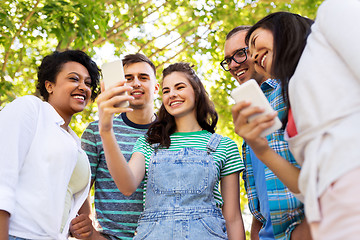 Image showing happy friends with smartphone at summer park