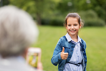 Image showing girl being photographed and showing thumbs up