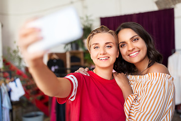 Image showing female friends taking selfie at clothing store