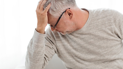 Image showing senior man suffering from headache at home