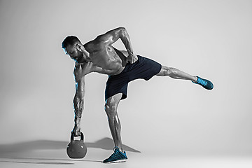 Image showing Young caucasian bodybuilder training over studio background