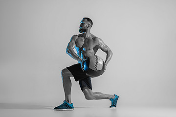 Image showing Young caucasian bodybuilder training over studio background