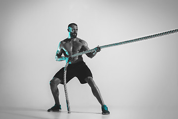 Image showing Young caucasian bodybuilder training over studio background