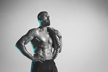 Image showing Young caucasian bodybuilder training over studio background