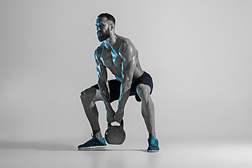 Image showing Young caucasian bodybuilder training over studio background