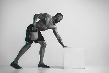 Image showing Young caucasian bodybuilder training over studio background