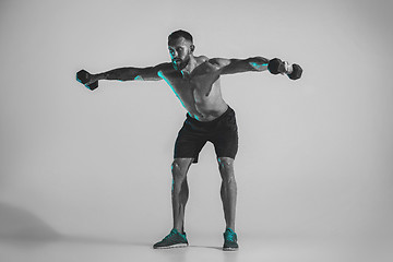 Image showing Young caucasian bodybuilder training over studio background