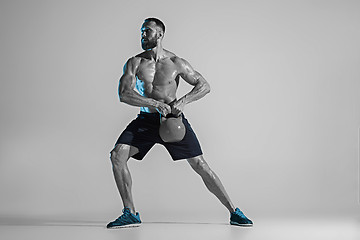 Image showing Young caucasian bodybuilder training over studio background