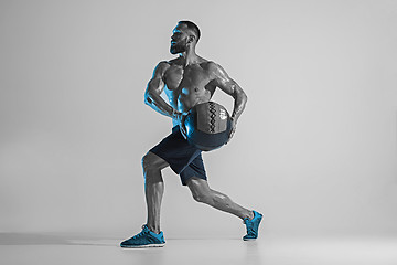 Image showing Young caucasian bodybuilder training over studio background