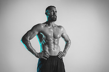 Image showing Young caucasian bodybuilder training over studio background