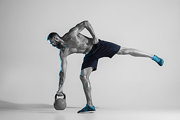 Image showing Young caucasian bodybuilder training over studio background