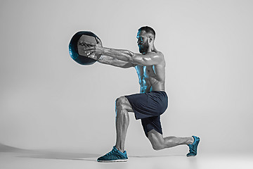 Image showing Young caucasian bodybuilder training over studio background