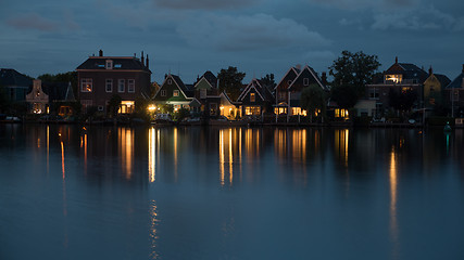 Image showing Waterside Dutch village with lights reflection on water at night