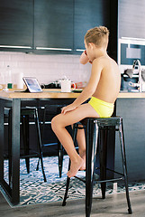 Image showing Child having breakfast and watching videos on tablet computer