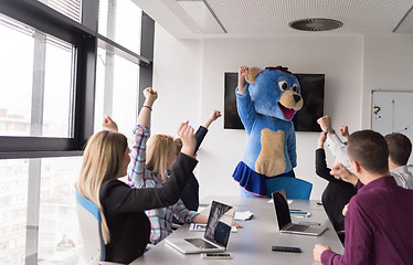 Image showing boss dresed as bear having fun with business people in trendy of