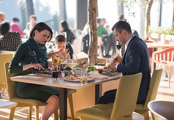 Image showing Young parents enjoying lunch time with their children