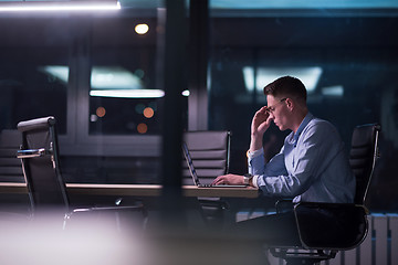 Image showing man working on laptop in dark office