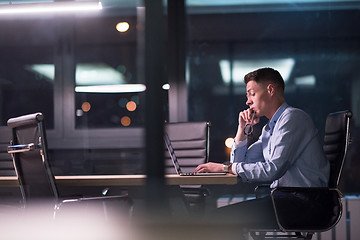 Image showing man working on laptop in dark office