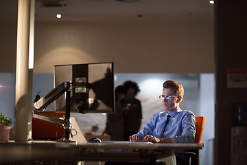 Image showing man working on computer in dark office