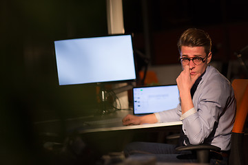 Image showing man working on computer in dark office