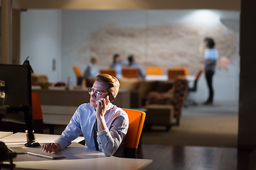 Image showing man using mobile phone in dark office