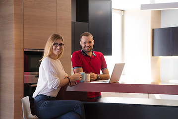 Image showing couple drinking coffee and using laptop at home