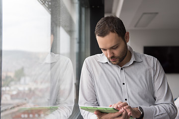 Image showing Businessman Using Tablet In Office Building by window