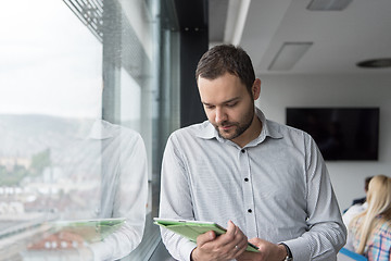 Image showing Businessman Using Tablet In Office Building by window