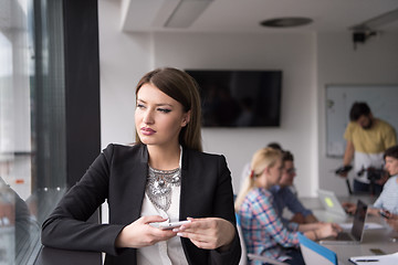 Image showing Business Girl Standing In A Modern Building Near The Window With