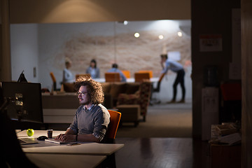 Image showing man working on computer in dark office