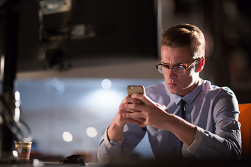 Image showing man using mobile phone in dark office