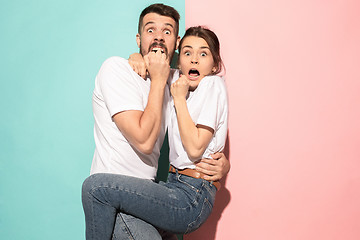 Image showing Portrait of the scared man and woman on pink and blue