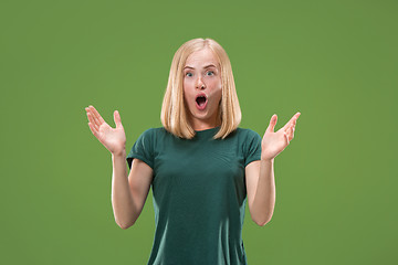 Image showing Beautiful woman looking suprised isolated on green