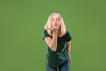 Image showing Portrait of attractive cute girl with kiss isolated over green background